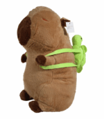 con rostro marrón oscuro y correas verdes brillantes de una mochila. El peluche está sentado mirando al frente