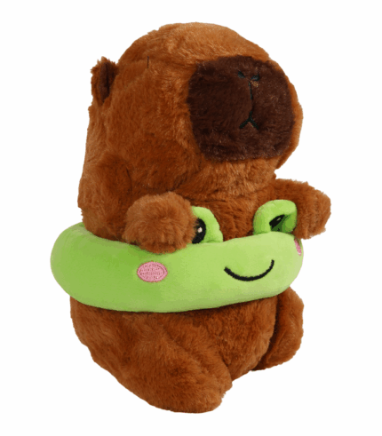 sentado y abrazando un peluche verde brillante con forma de rana que le rodea el cuerpo.