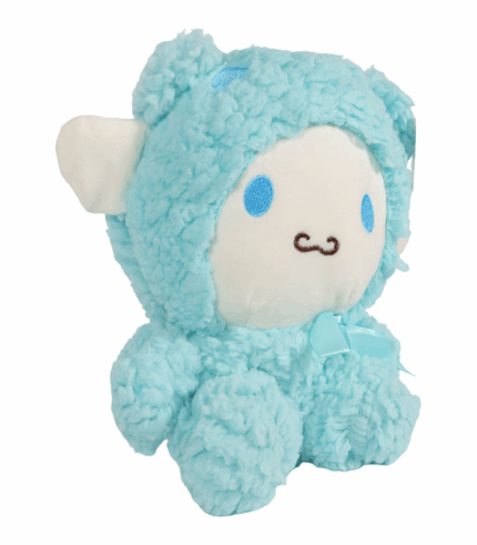 vestido con un traje de oveja fluffy de textura rizada. El peluche tiene un lazo azul claro en el cuello y está fotografiado sobre un fondo blanco.