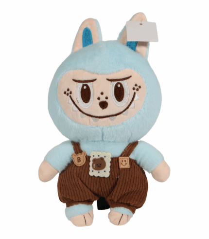 Peluche Labubu azul celeste de cuerpo suave y orejas grandes. Viste un overol de pana marrón con tirantes y parches decorativos